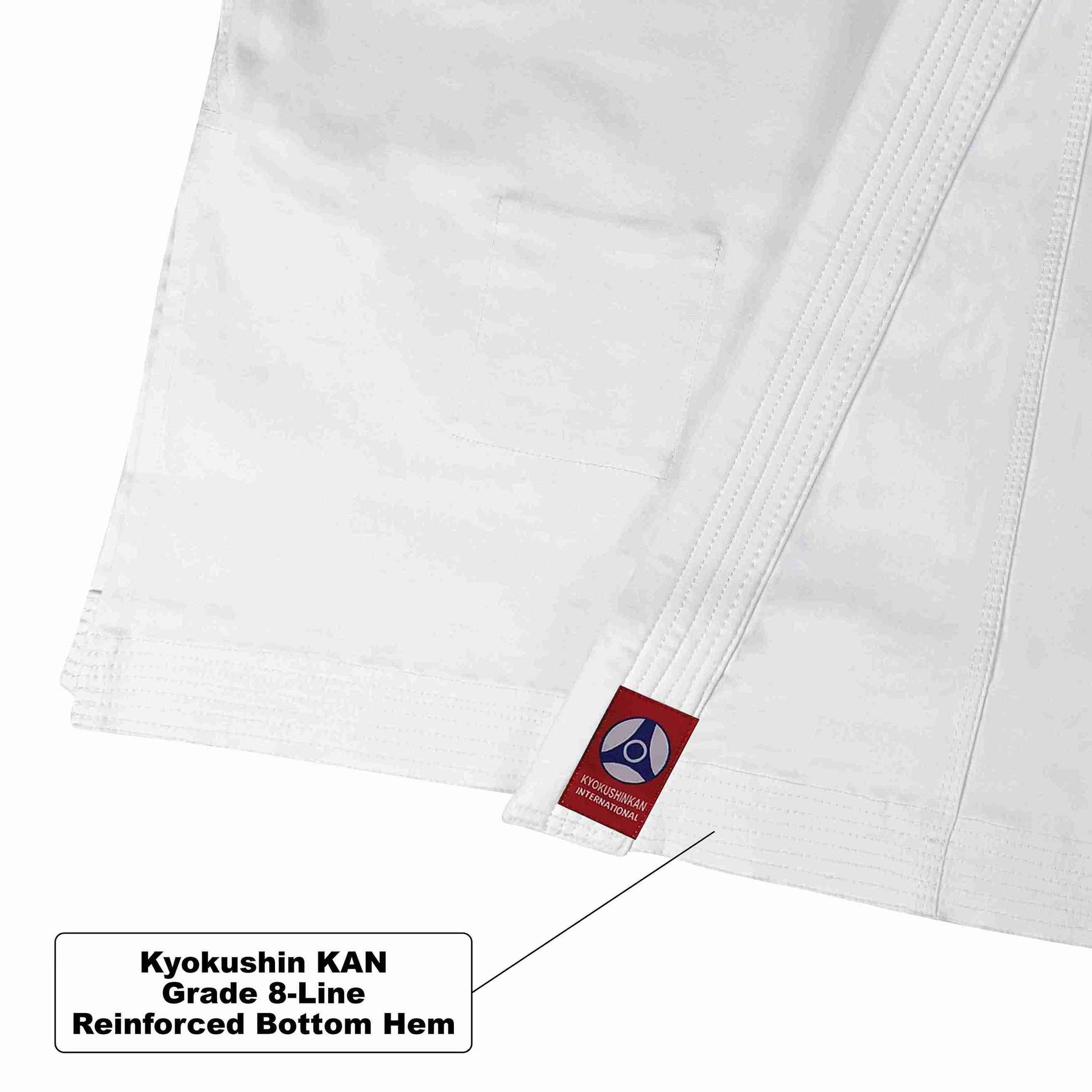 Close-up of a white martial arts uniform showing a reinforced bottom hem with a small red Kyokushin KAN, plus a text callout explaining the reinforced hem.