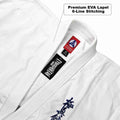 Close-up of a white martial arts uniform jacket with a collar, showing sewn-in labels including a red and black logo patch and a black rectangular brand tag. A text callout reads 'Premium EVA Lapel 6-Line Stitching.
