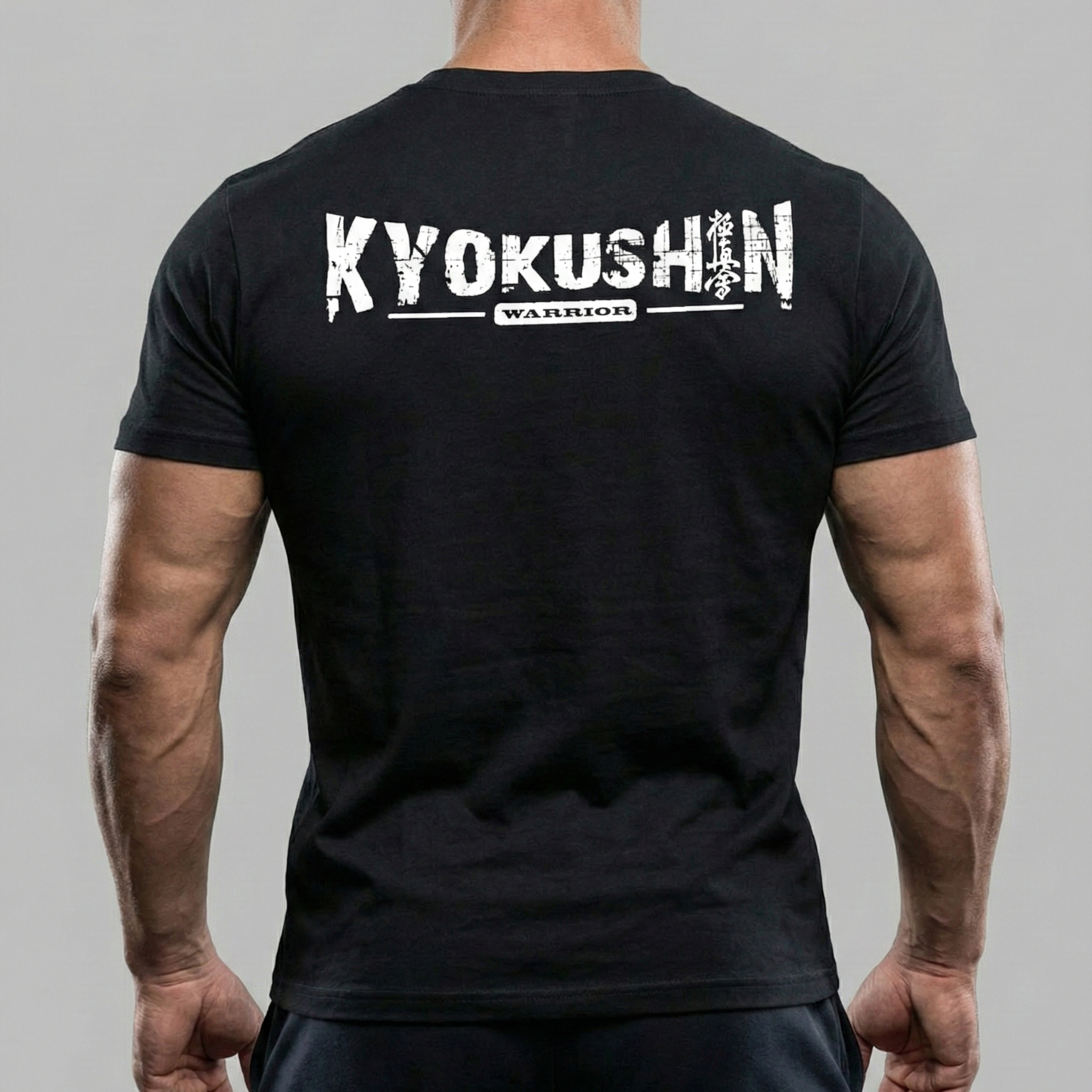 Person wearing a black t-shirt with 'Kyokushin Warrior' text on the back against a gray background